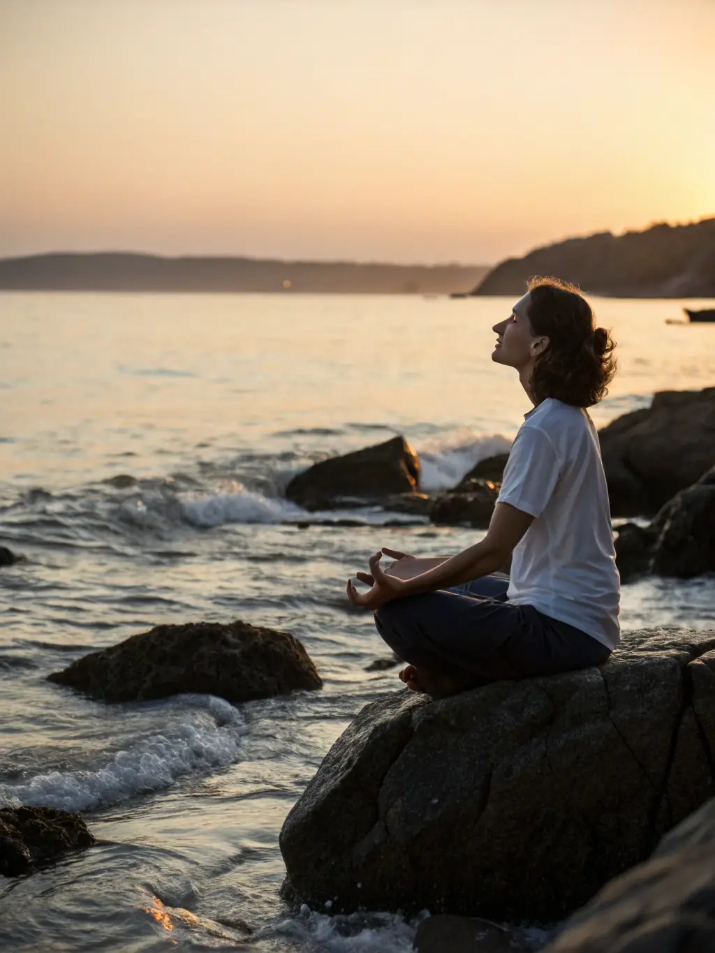 An image of a person meditating peacefully in a serene natural setting, such as a forest or beach, with soft, diffused lighting. This represents the stress reduction and mindfulness aspects of the mental wellness program.